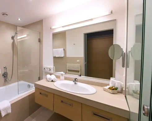 Bright bathroom with shower, toilet, sink and heated towel rail