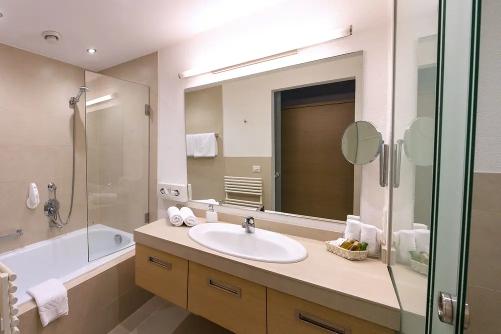 Bright bathroom with shower, toilet, sink and heated towel rail